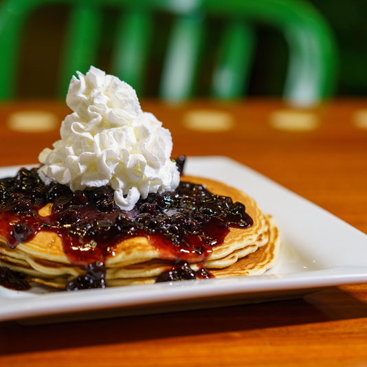pancakes topped with blueberry compote and whipped cream